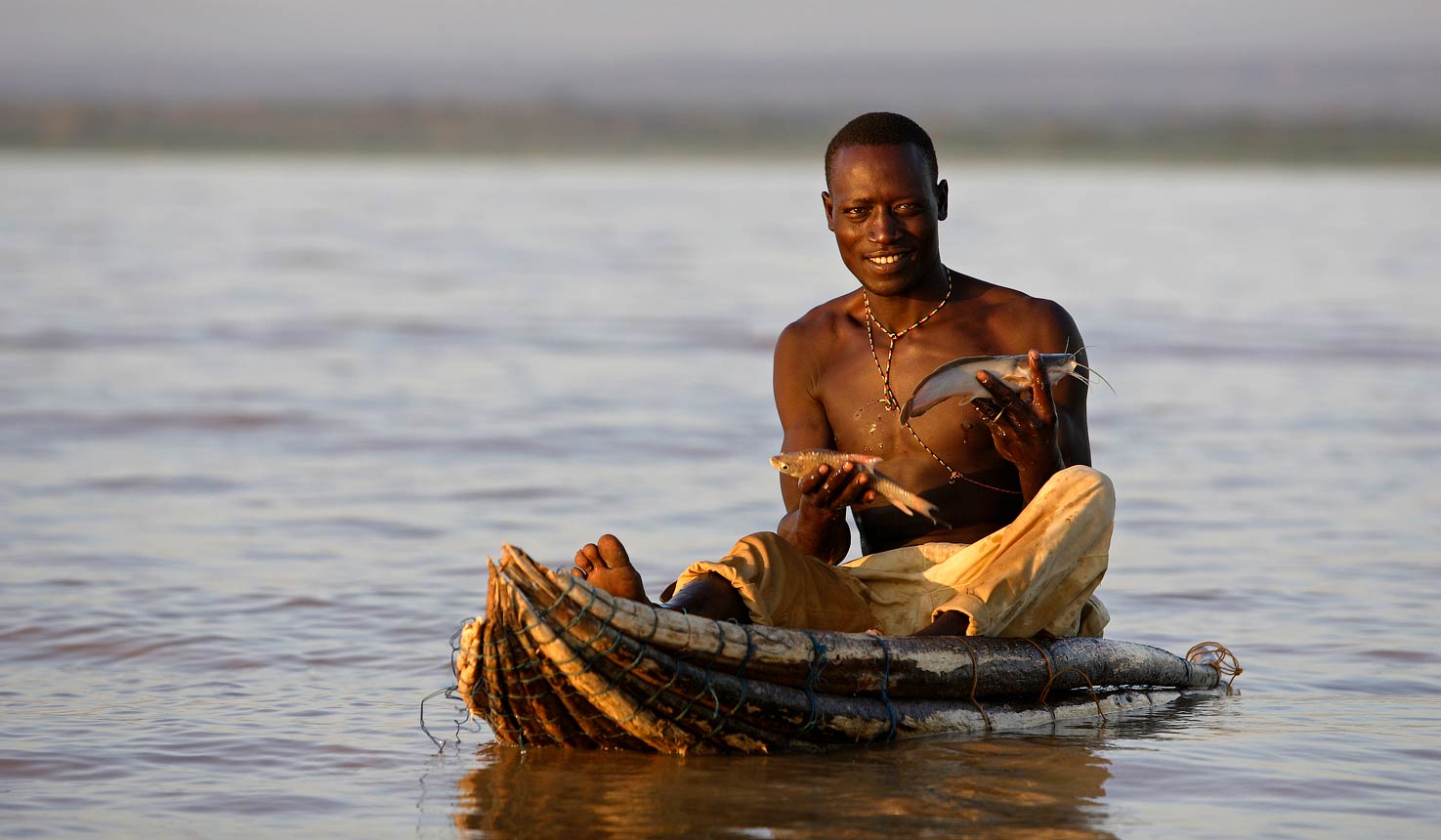 Two men fishing in a small boat on the Lake Baringo. Kenya, Africa